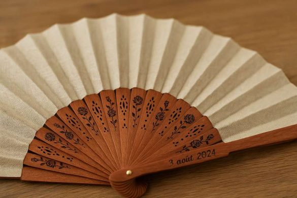 Un élégant "éventail personnalisé avec une gravure" en bois sur les montants, parfait pour un mariage ou un événement spécial